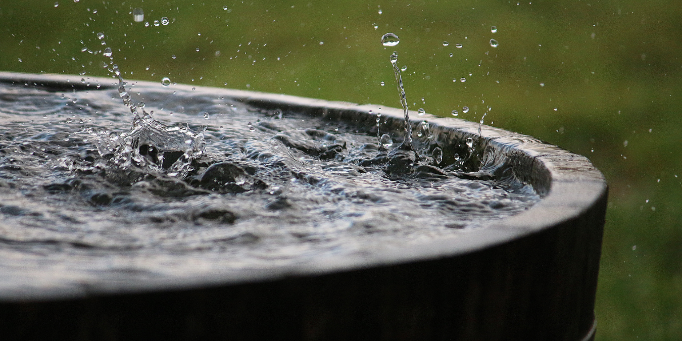 Raindrops splashing into collection bucket